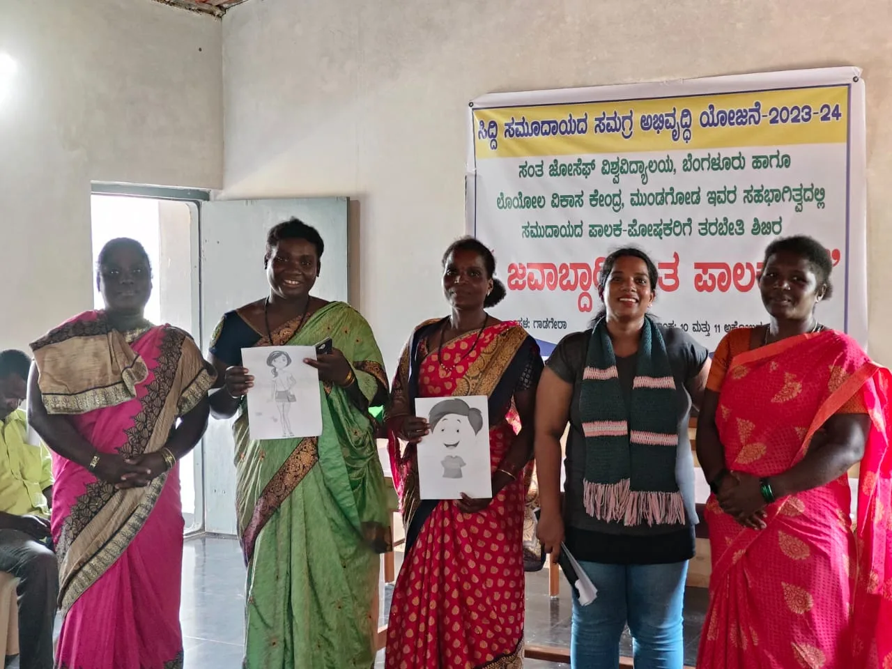 Siddi community women holding their artwork and sketches during the Responsible Parenting workshop